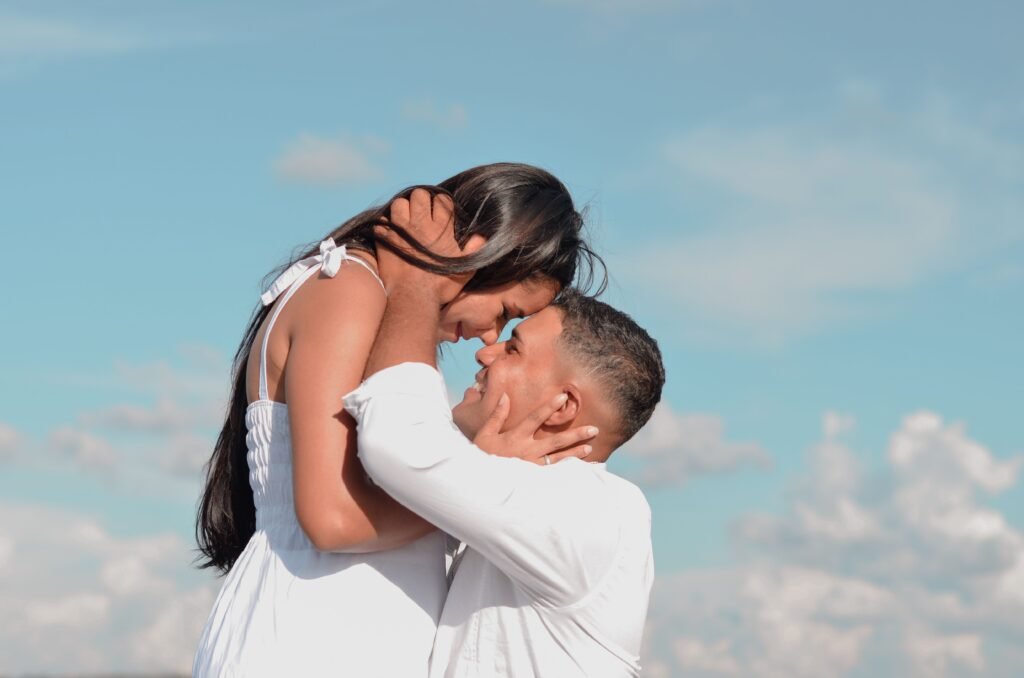 Imagen actual: A couple in love embracing under a clear blue sky, exuding romance and warmth.